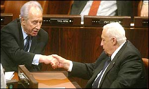 Israeli foreign minister Shimon Peres (left) shakes hands with Prime Minister Ariel Sharon after the vote in the Knesset