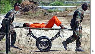 US guards carry suspect off for interrogation at Guantanamo Bay