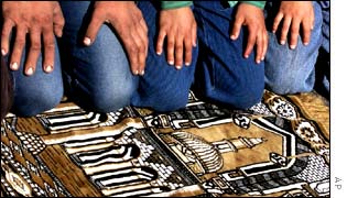 Worshipers pray on a rug with the picture image of the Al Aqsa Mosque in the West Bank town of Hebron