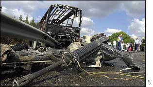 Israeli army rifles lie scattered around the burnt out bus