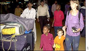Unidentified British consulate official, right, prepares to leave country from Karachi airport in Pakistan 