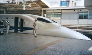 Train drivers next to a shinkansen at Tokyo station