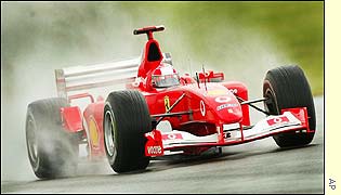 Michael Schumacher speeds through the rain at Silverstone