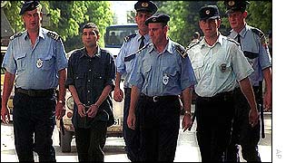 Nikolic is led to the court by Serbian police officers