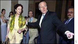 The new foreign minister is shown to her office by her predecessor 
