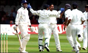Mark Butcher trudges off the pitch as India celebrate their second wicket of the day 