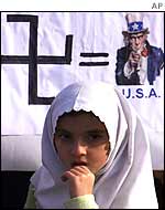 A Turkish girl stands in front of an anti-American  poster
