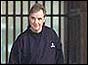 Jonathan Aitken with prison gate behind him