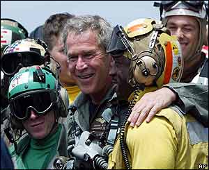 President Bush with helmeted carrier crew  