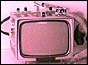 Tiny tv being held in between a thumb and forefinger