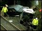 Rescue workers with the wreckage of the Land Rover and trailer