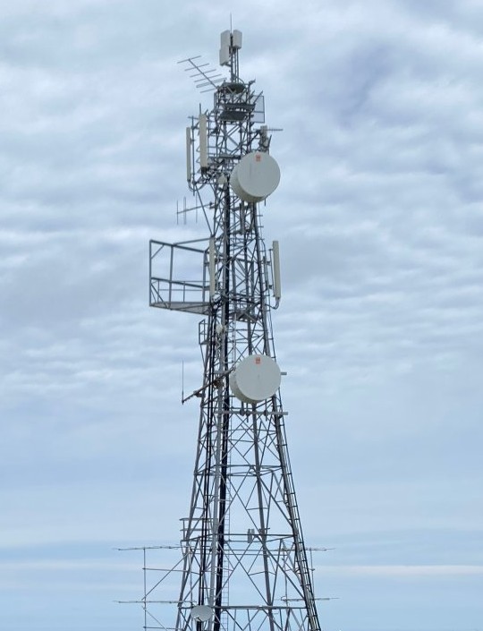 Image of the Alderney transmitter on a day with a blue sky and white clouds in the background behind the transmitter.