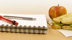 Notepad, pen and an apple