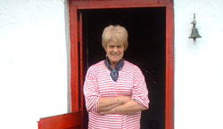 Josie McMullen at the front door of the thatched cottage