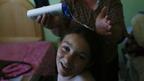 Somebody pouring shampoo onto a girl's hair
