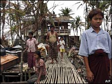 Một gia đình người Miến Điện trước ngôi nhà bị bão phá hủy 