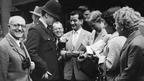 BBC 'English by Radio' Summer School students stand outside the Old Curiosity Shop in London talking to a policeman