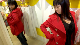 Girl trying on red coat