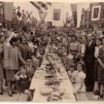 This is a street party on VE day held at Wesley Grove Portsmouth.  My parents are in the forground my father to the right wearing his office suit my mother is at the front on the left.
