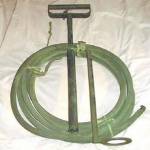 Stirrup Hand-pump with dual jet and spray nozzle. Used to extinguish the Magnesium {Electron) bomb (incendiary bomb). 30 feet of hose could be used by fire-guards at a safe distance from heat and fire.  A jet of water could be fired from 30 feet or as a spray at 15 feet.