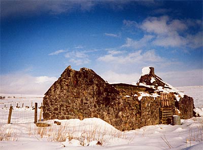 Photo showing a roofless cottage in the snow under a crisp blue sky