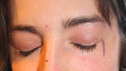 A close-up of Nicola's face at the end of the beauty ritual, complete with skewed eyeliner streak, and a mascara stain on her nose