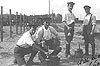 POW's pose at wire fence