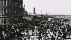 A large beach crowded with various people in Victorian dress.