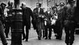 Father Edward Daly leads a group of people carrying the mortally wounded Jackie Duddy, waving a white handkerchief