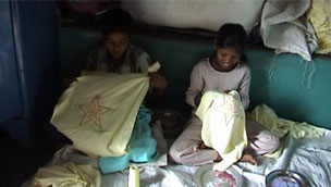 Two girls sewing sequins