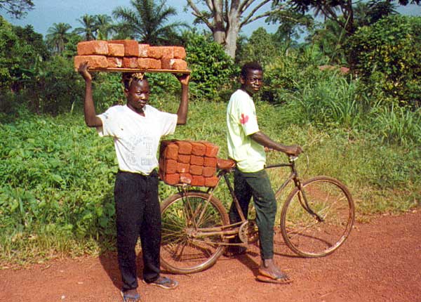 Children delivering hand-made bricks to build their new school