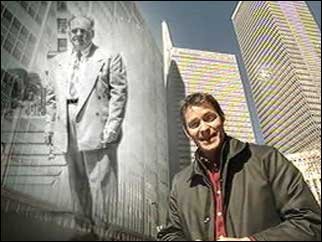 Morland Sanders standing next to  a picture of Albert Osborne